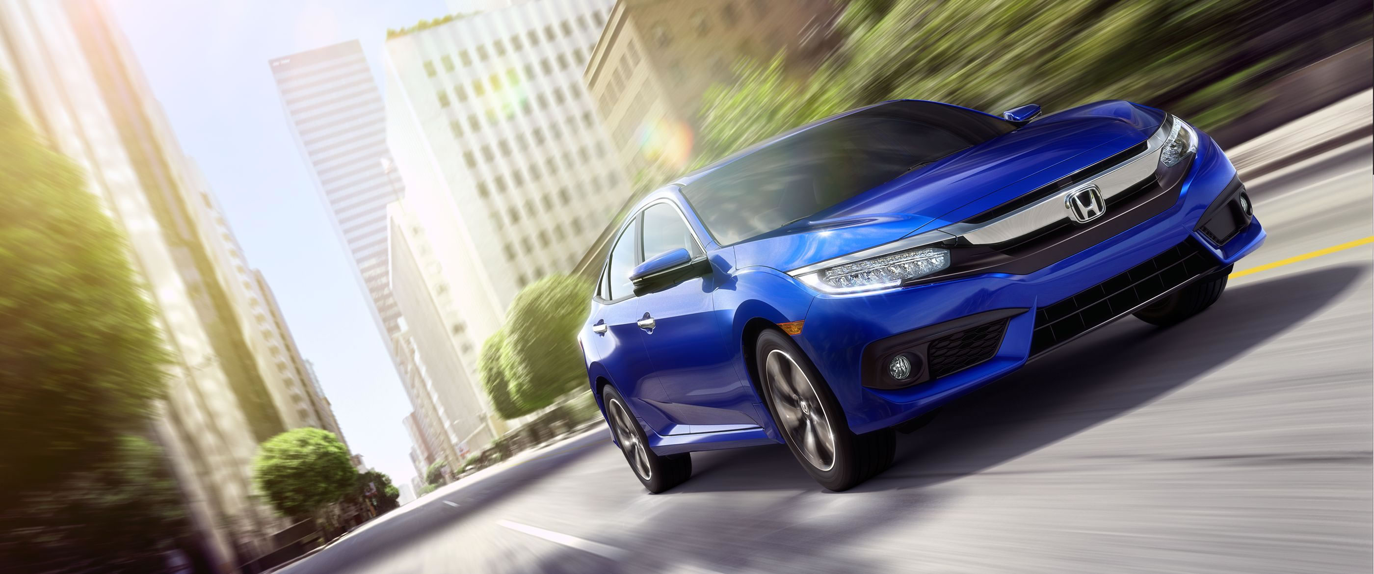 2016-civic-sedan-touring-ext-b-593m-78-front-pass-driving-city-1400-2x